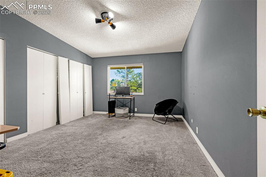 Image 15 of 29: Office space with carpet floors and a textured ceiling