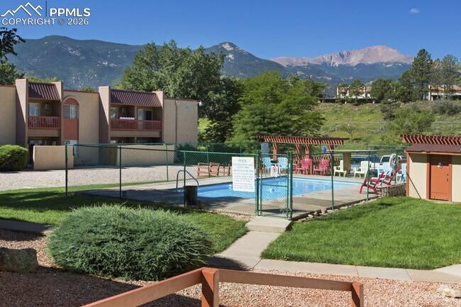 Image 32 of 33: Outdoor swimming pool surrounded by a chain-link fence, concrete patio, and