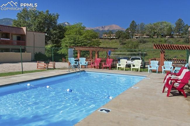Image 33 of 33: Swimming pool with concrete decking and mountain scenery