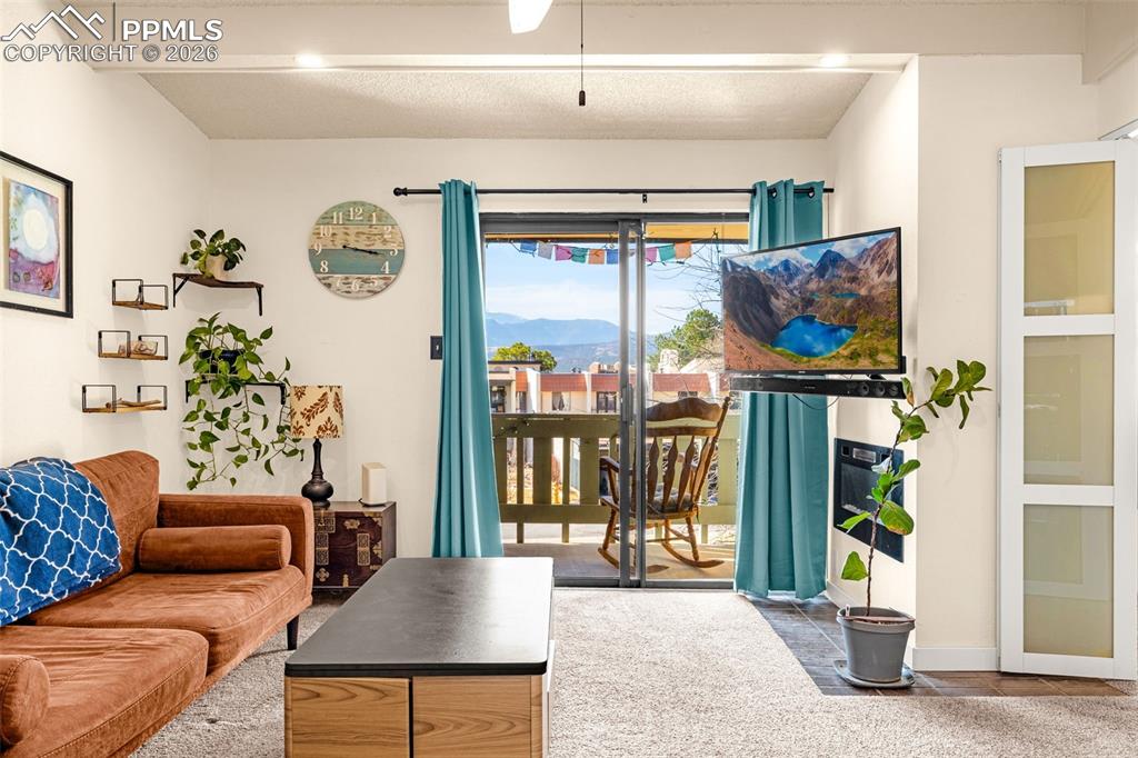 Image 9 of 29: Living room featuring beam ceiling and baseboards