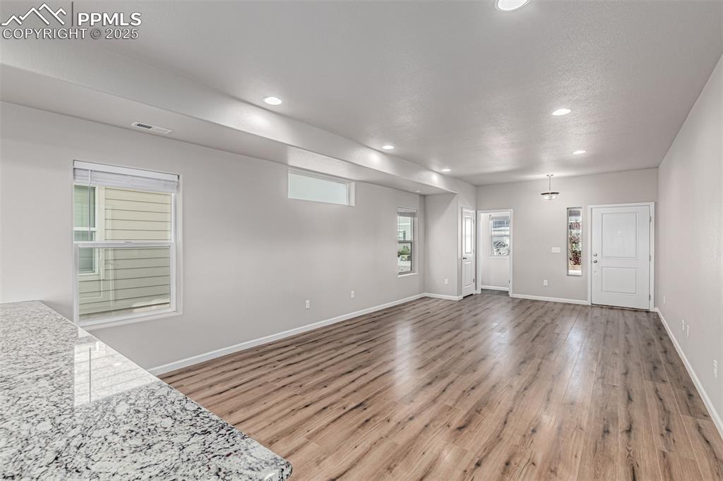 Image 5 of 29: Unfurnished living room featuring light wood finished floors and recessed l