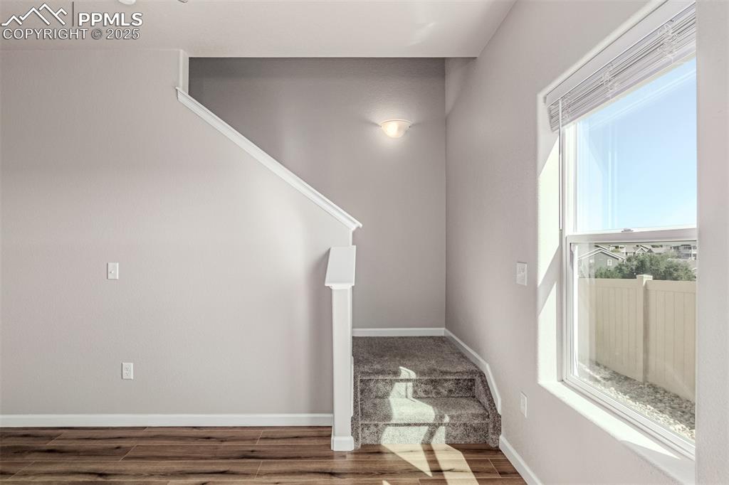 Image 7 of 29: Stairway featuring baseboards and wood finished floors
