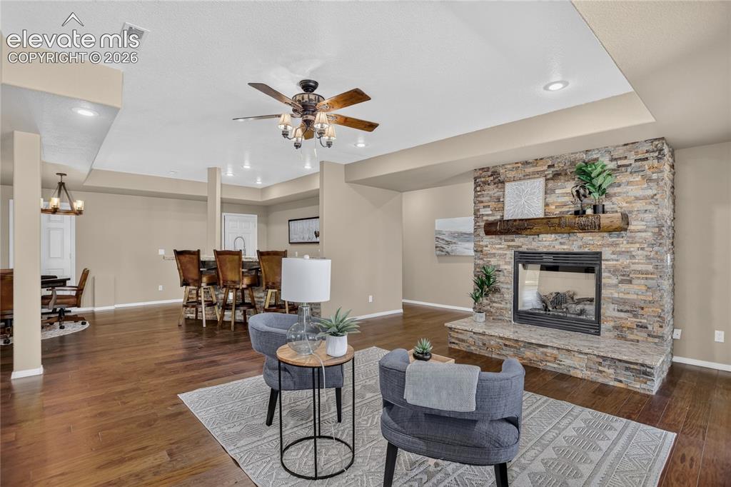 Image 21 of 37: Family room includes gas fireplace w/ custom mantle & chiseled-edge granite