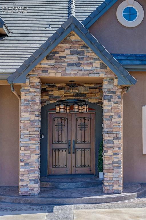 Image 3 of 37: Mahogany door w/ speakeasy door & wrought iron grill and large, rustic chan