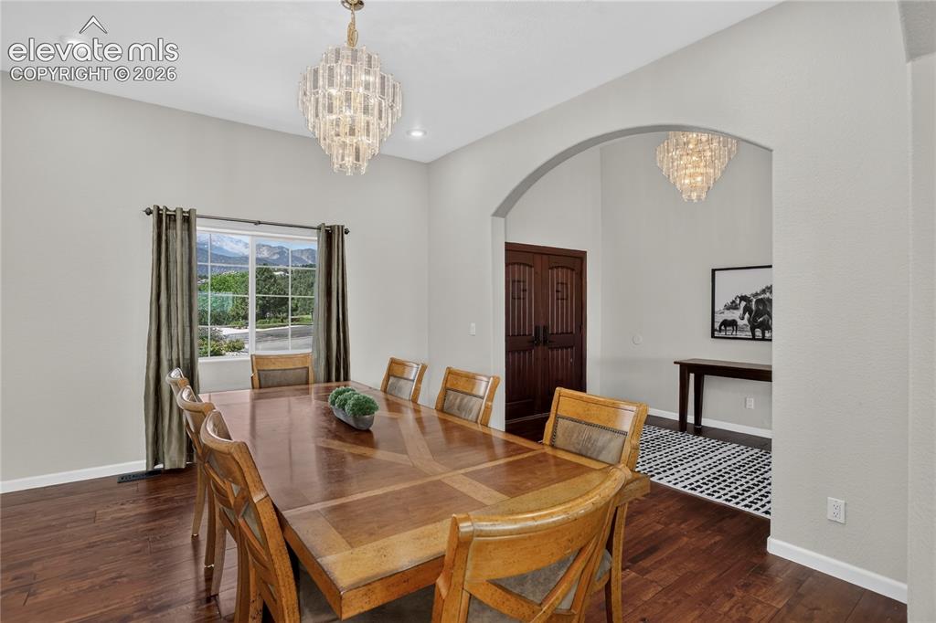 Image 5 of 37: Formal dining with window framing Pikes Peak