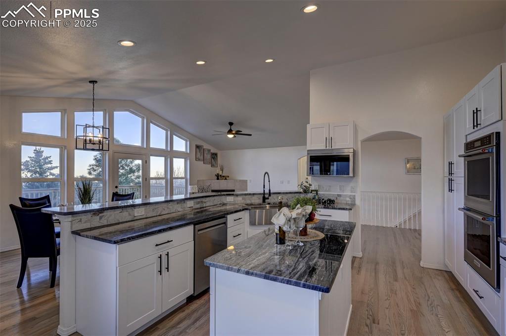 Image 16 of 50: Gourmet Island Kitchen with views into the Great Room, Dining Area, and Fro