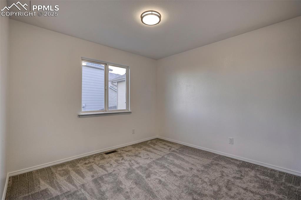 Image 25 of 50: Main Level Bedroom #2 with new carpet and a generous closet. Views of backy