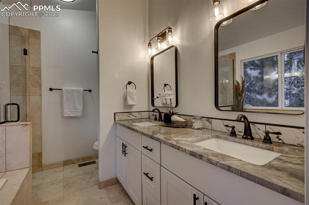 Image 31 of 50: Luxurious remodeled Primary Bathroom with new toilet, dual sink vanity with