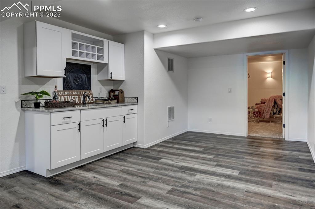 Image 38 of 50: Custom wet bar with quartz countertop and built in wine rack.