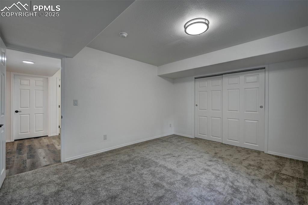 Image 47 of 50: Basement Bedroom #5 has new carpet and a generous closet.