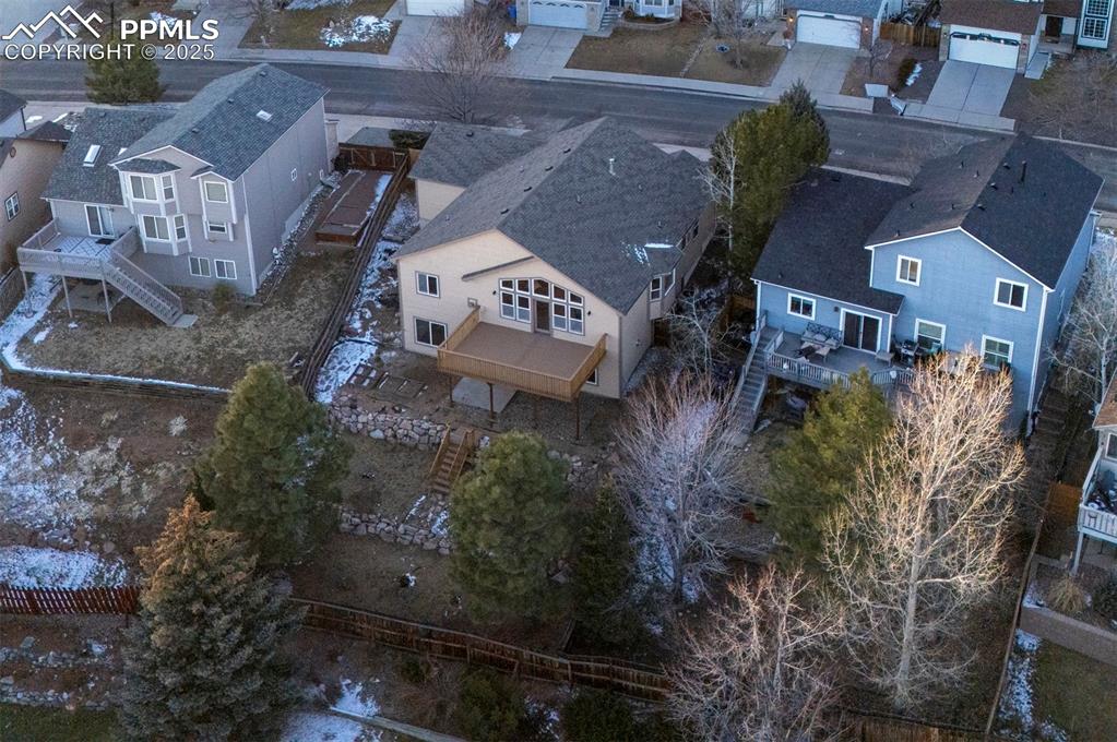 Image 49 of 50: Sunset view of fenced, terraced backyard with raised planters, a composite