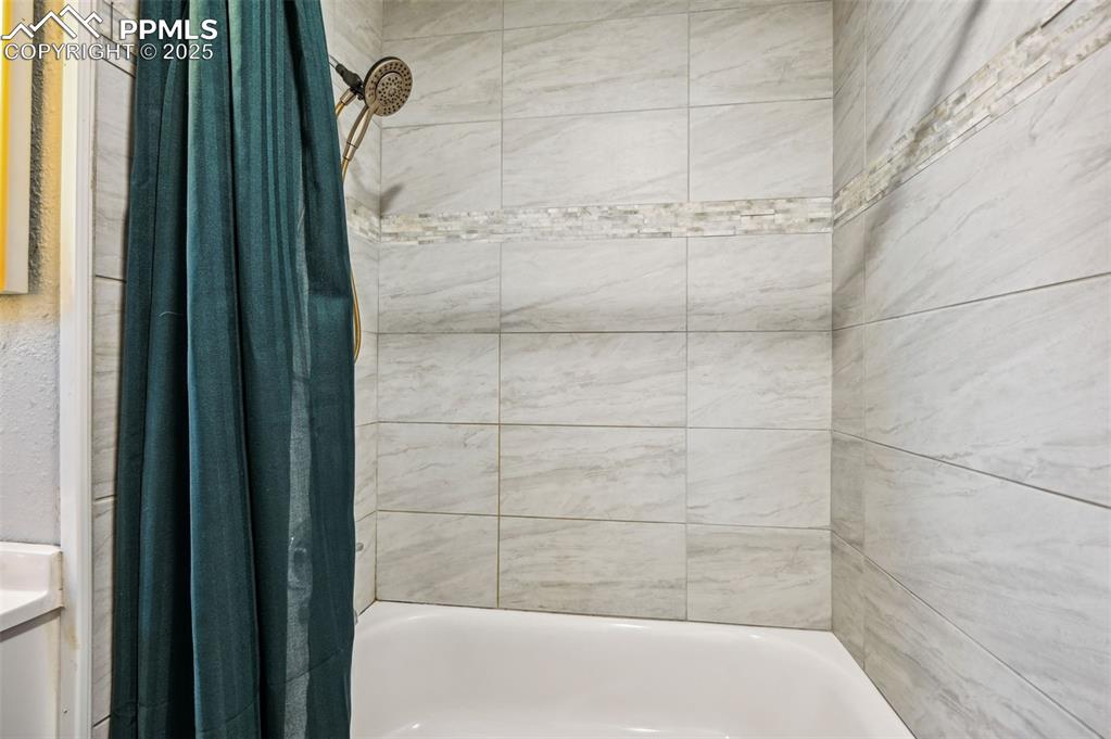 Image 14 of 27: Full bathroom with shower / bathtub combination with curtain