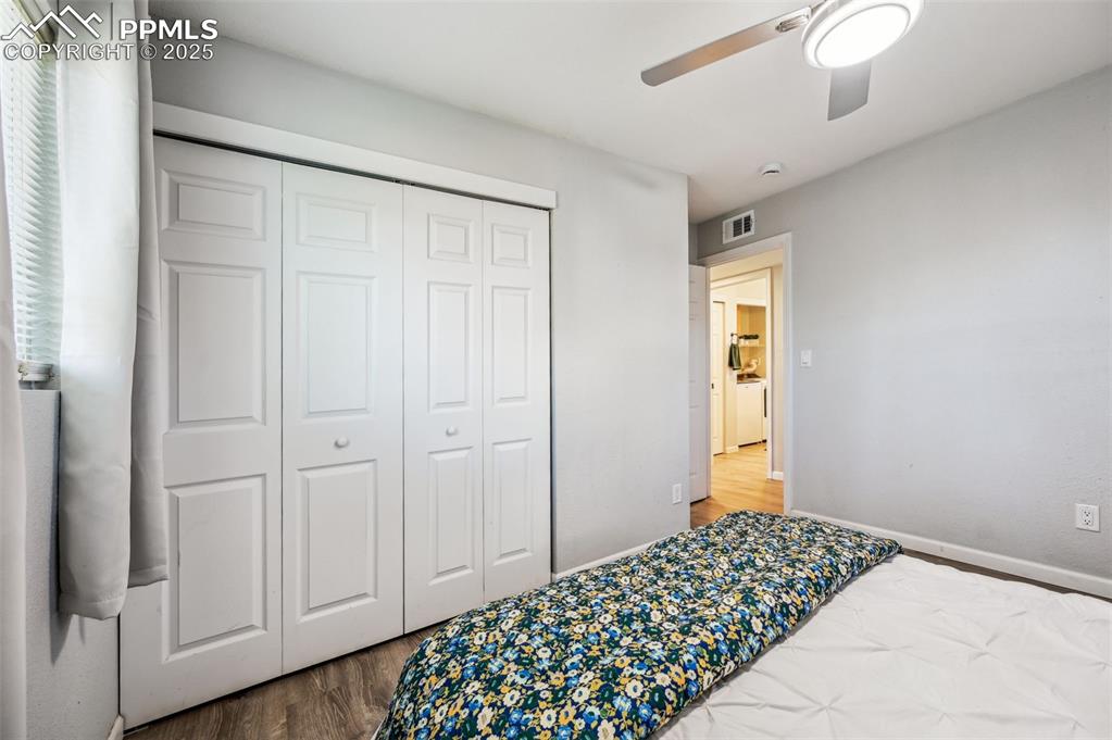 Image 16 of 27: Bedroom with wood finished floors, ceiling fan, and a closet