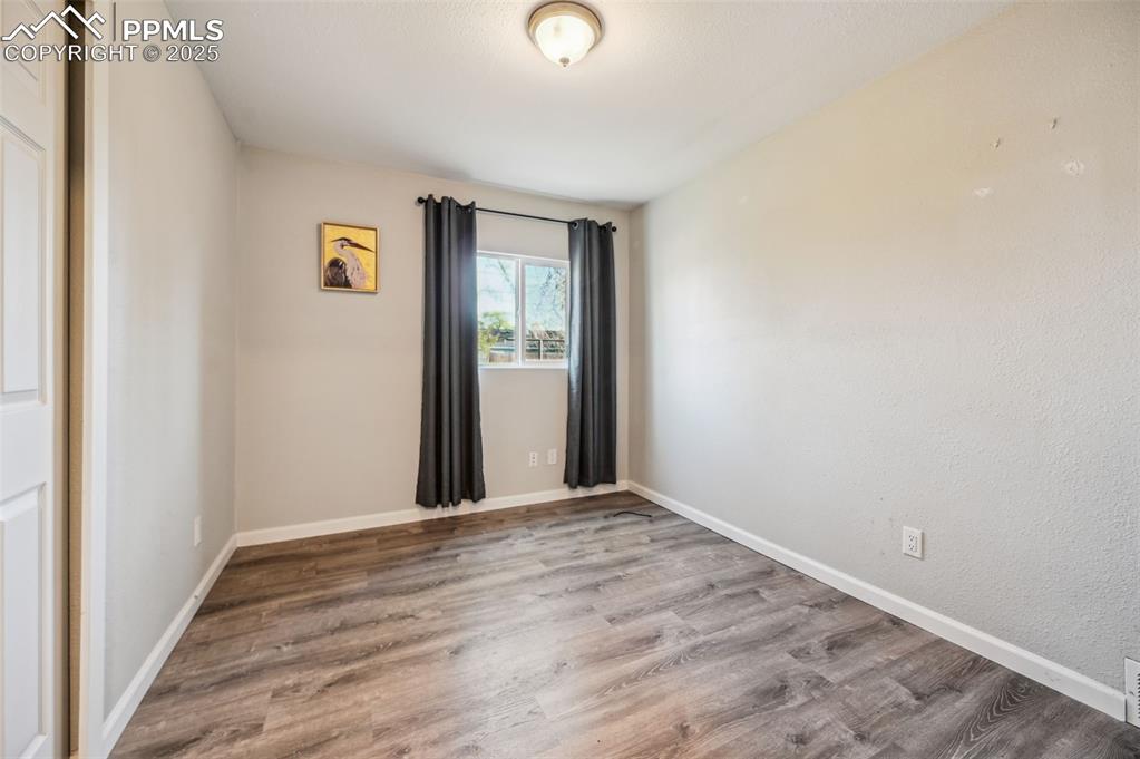 Image 17 of 27: Unfurnished room featuring wood finished floors and baseboards