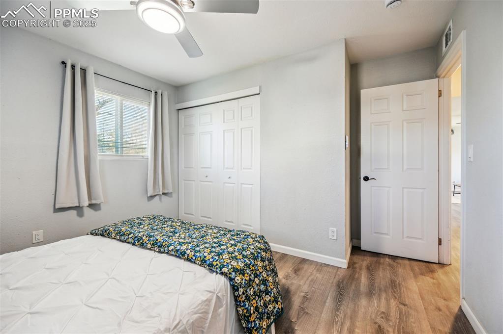 Image 18 of 27: Bedroom with wood finished floors, ceiling fan, and a closet