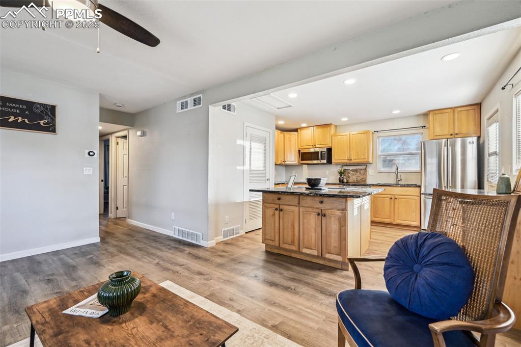 Image 6 of 27: Kitchen with appliances with stainless steel finishes, dark stone counterto