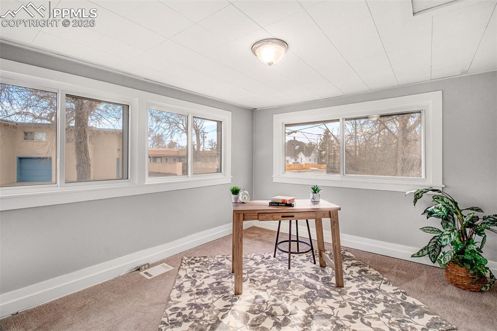 Image 11 of 24: Second main level bedroom with wrap around windows for amazing light