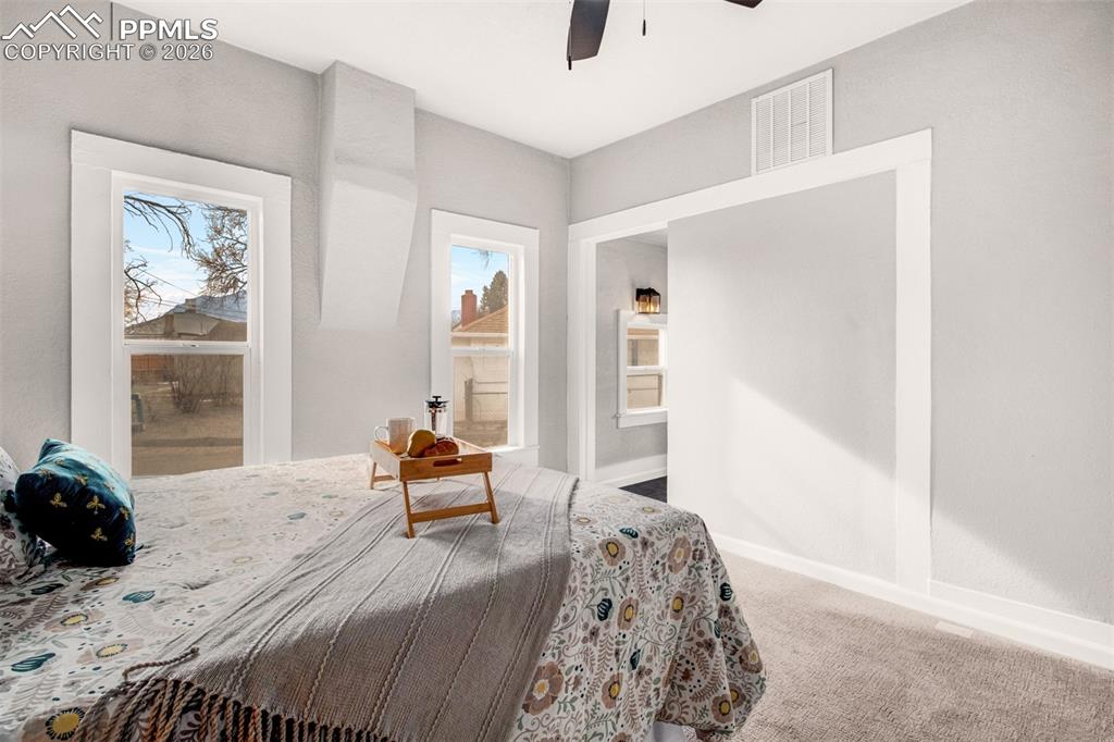 Image 9 of 24: Master bedroom with carpet, ceiling fan and ensuite bath