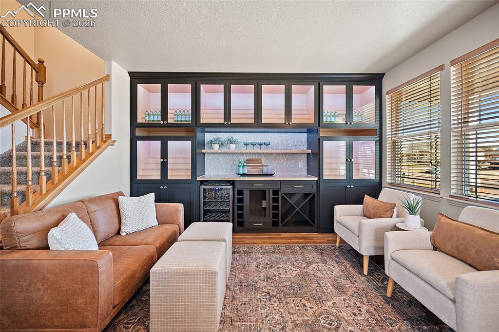 Image 6 of 50: Stunning entertaining lounge as you walk in with a custom built in bar!