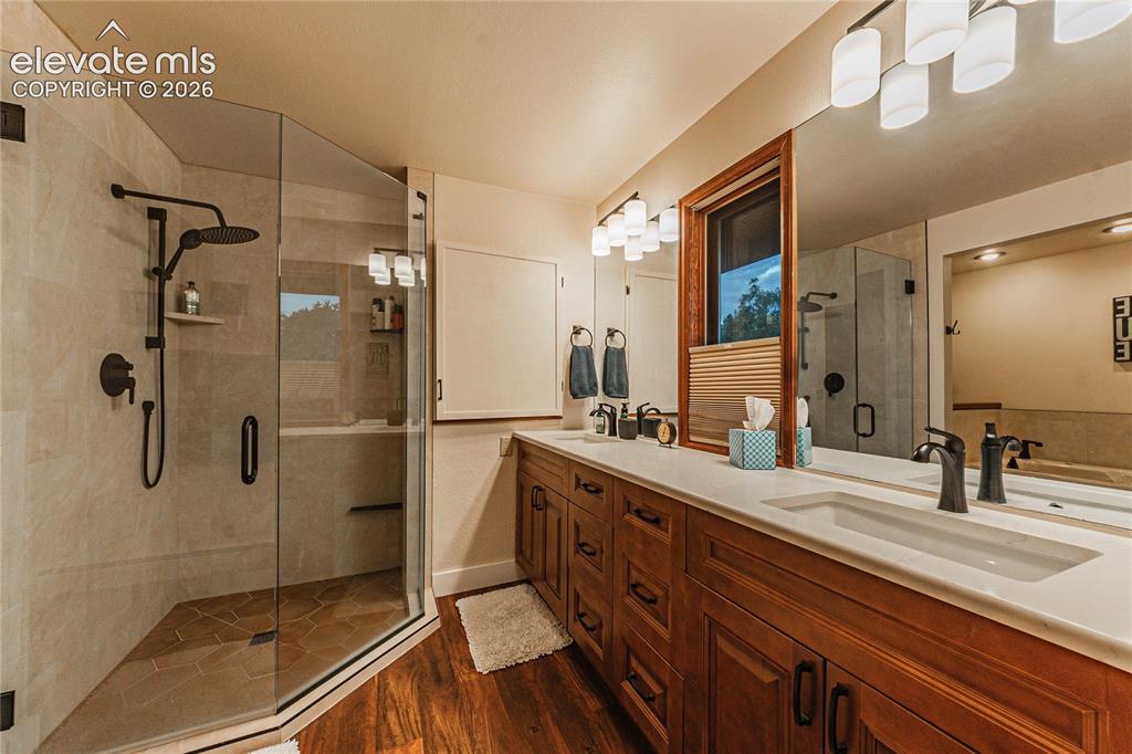 Image 22 of 43: Bathroom with hardwood / wood-style floors, a shower with door, and vanity