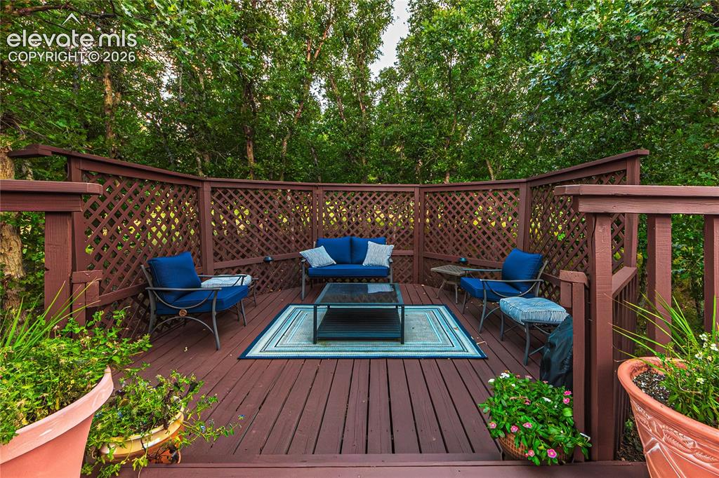 Image 38 of 43: Wooden deck with an outdoor living space with a fire pit