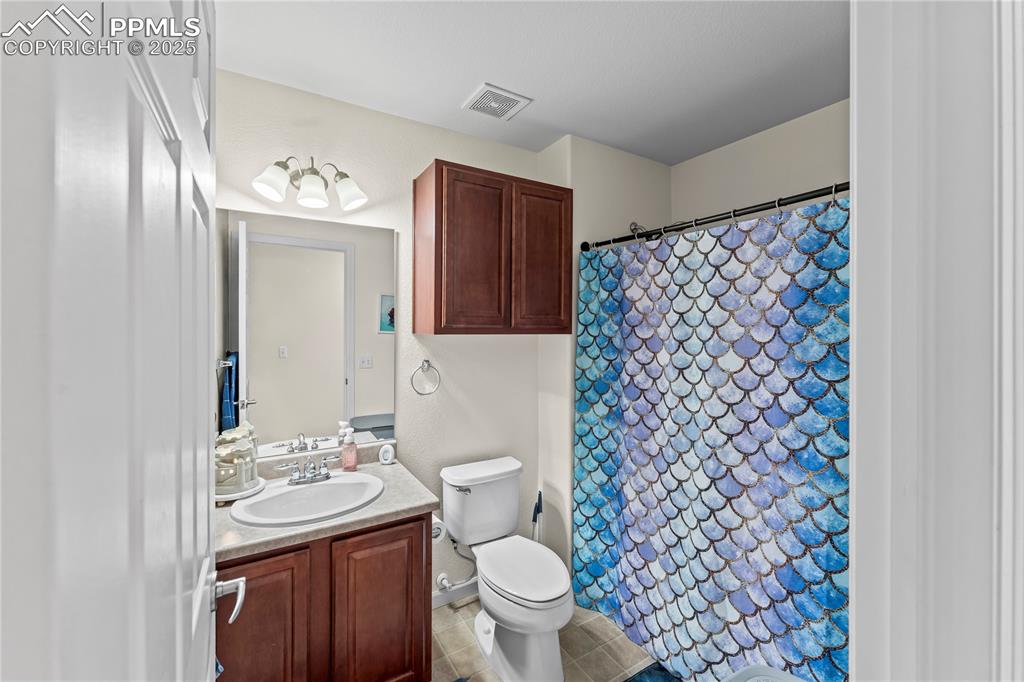 Image 16 of 25: Full bath featuring vanity, a shower with curtain, and light tile patterned