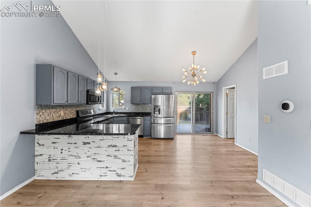 Image 10 of 37: Kitchen with appliances with stainless steel finishes, a peninsula, a chand