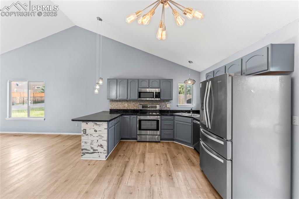 Image 11 of 37: Kitchen with appliances with stainless steel finishes, gray cabinets, a cha