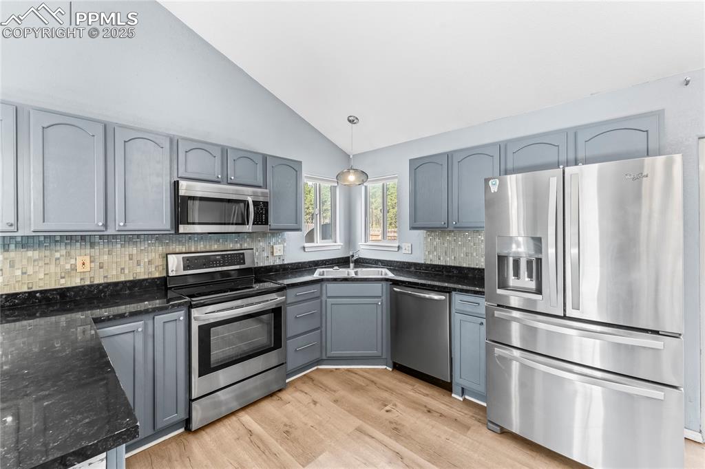 Image 12 of 37: Kitchen featuring appliances with stainless steel finishes, dark stone coun
