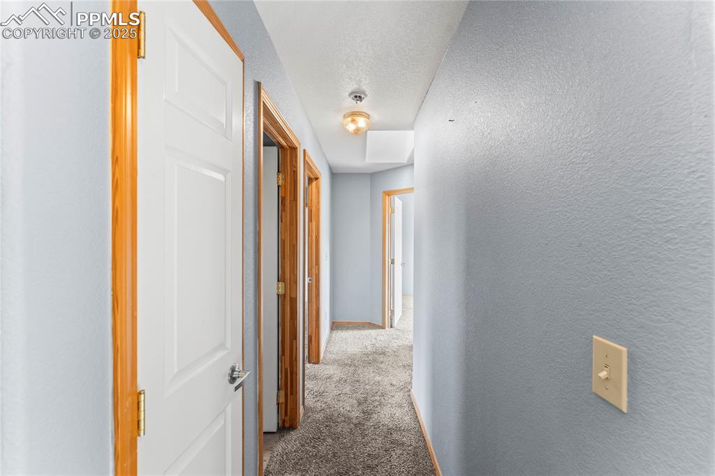 Image 19 of 37: Upstairs Corridor with carpet flooring, a textured ceiling, and a textured