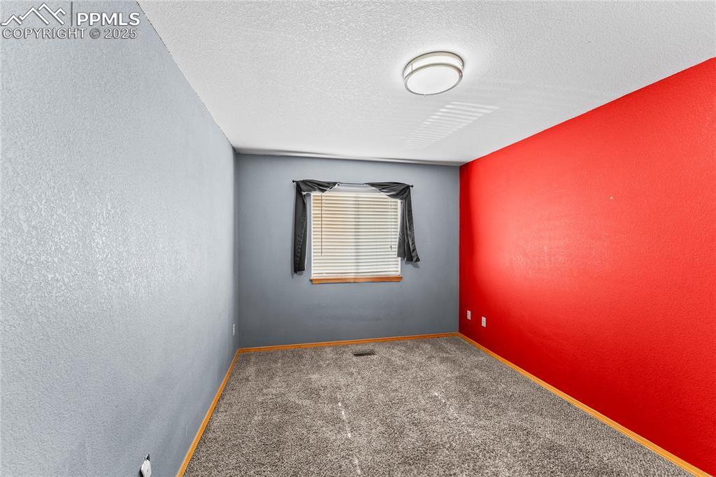 Image 25 of 37: 2nd Floor Bedroom Spare room featuring carpet, a textured ceiling, and a te