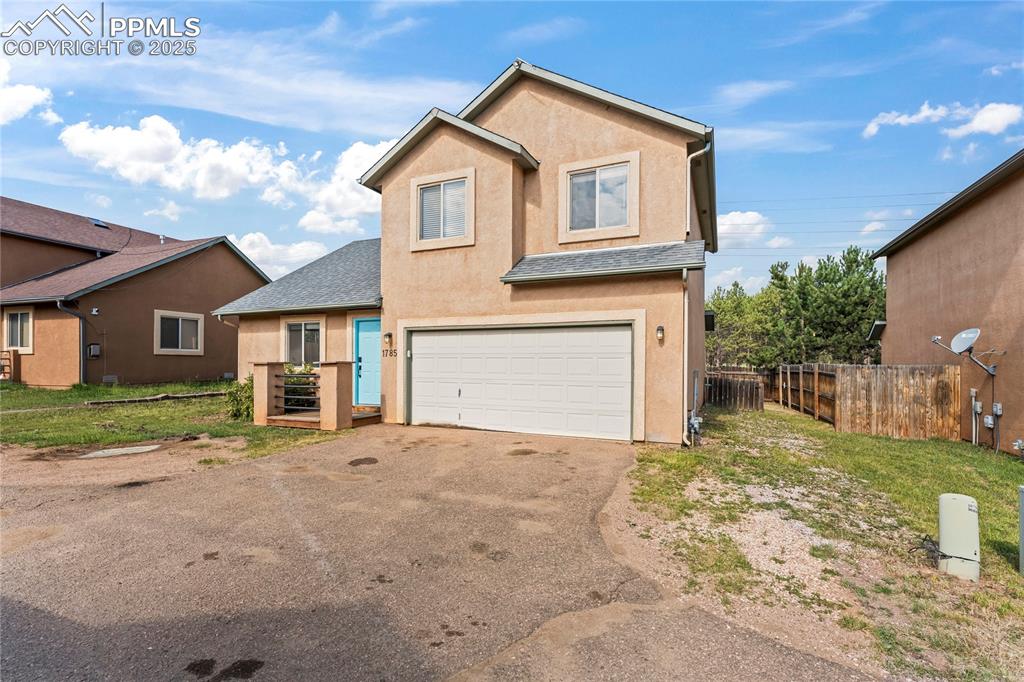Image 3 of 37: Traditional home with stucco siding, driveway, an attached garage, and roof