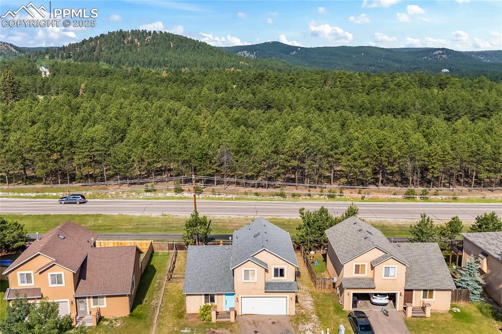 Image 30 of 37: Aerial perspective of suburban area featuring a heavily wooded area and a m