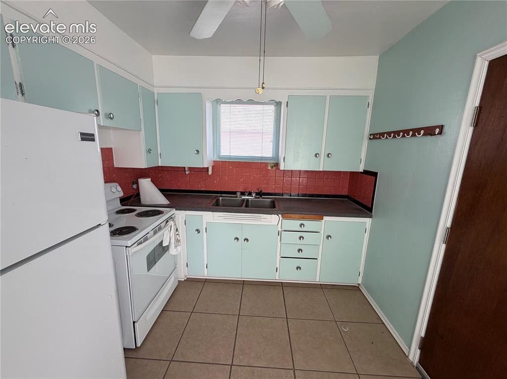 Image 3 of 28: Kitchen featuring light-toned cabinetry, a red tile backsplash, a ceiling f