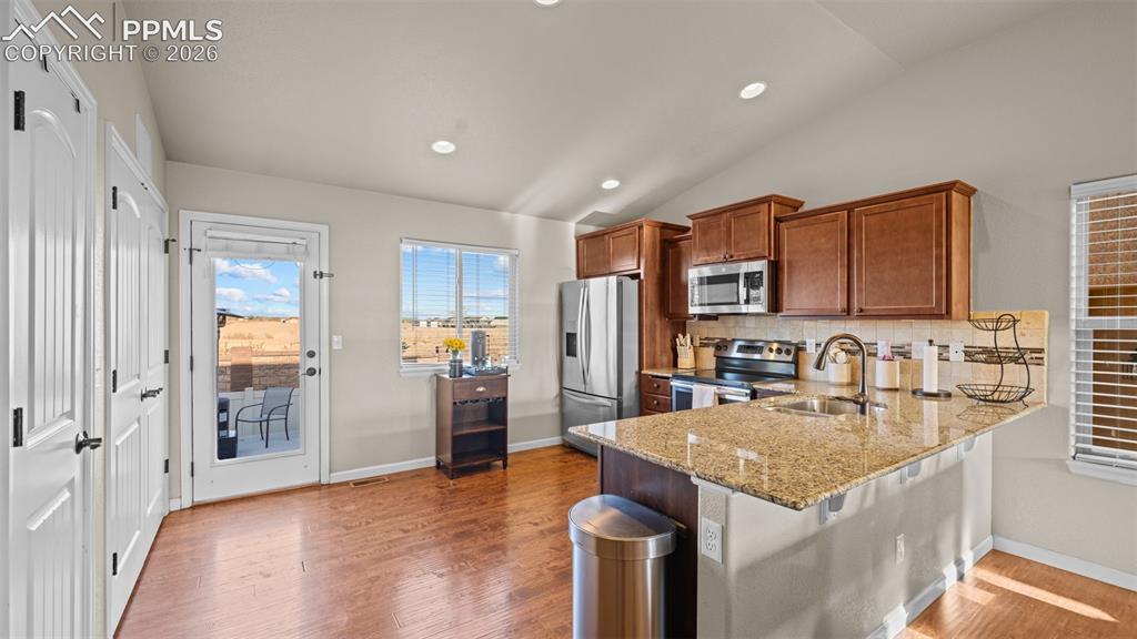 Image 10 of 27: Kitchen featuring wood-finish flooring, recessed lighting, and vaulted ceil