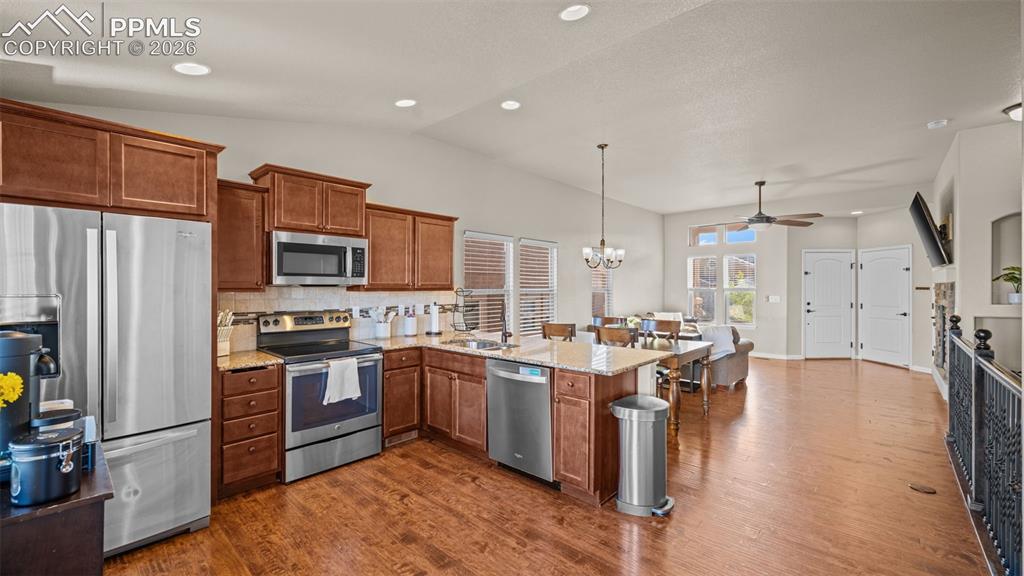 Image 11 of 27: Open-concept kitchen featuring wood-finish flooring, recessed lighting, sta
