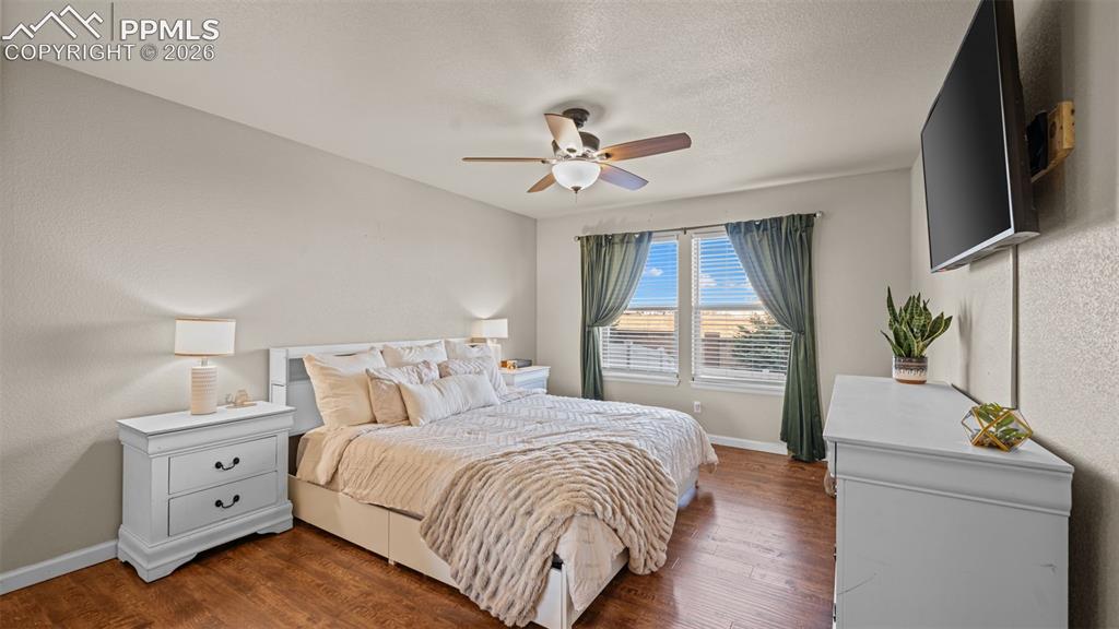 Image 14 of 27: Spacious room with wood-finish flooring, light-colored walls, and a ceiling