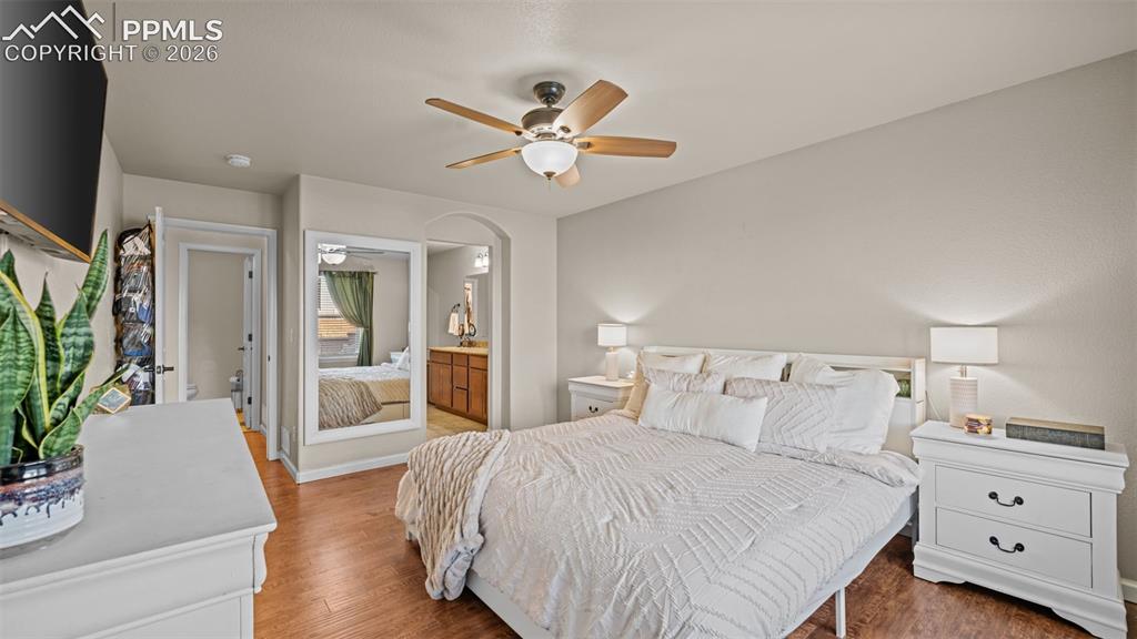 Image 15 of 27: Bedroom featuring wood-finish flooring, a ceiling fan, and a light neutral