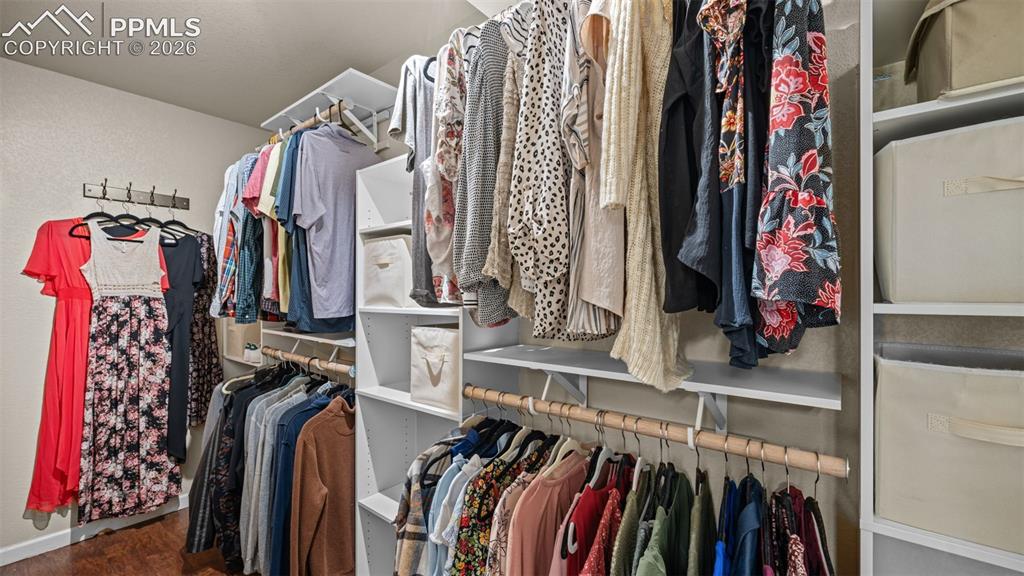Image 17 of 27: Custom closet system featuring multiple hanging rods, integrated shelving,