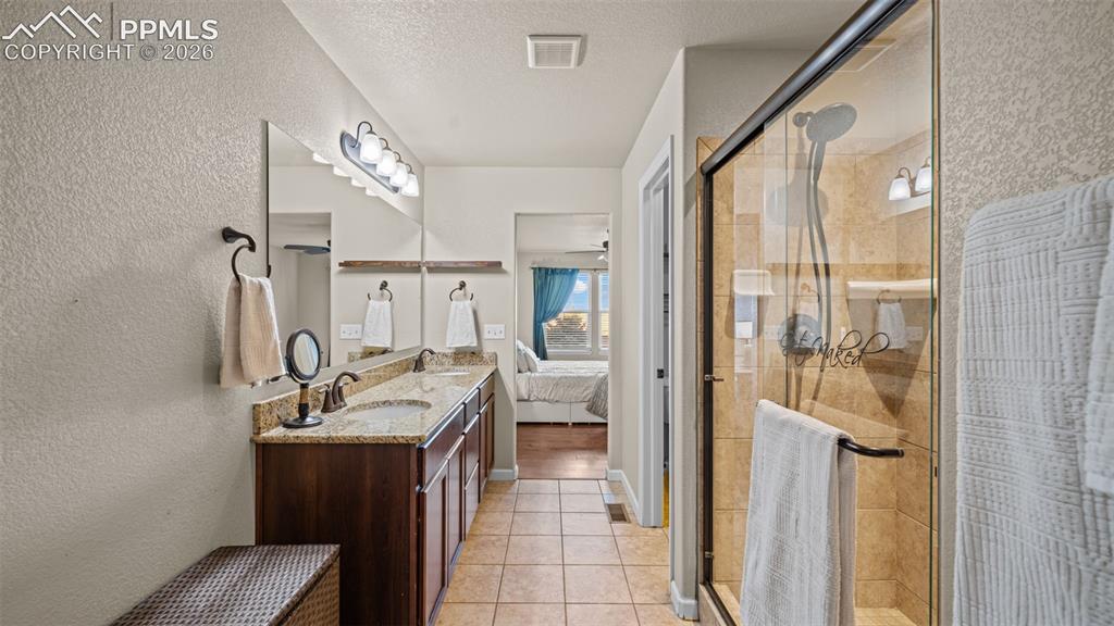 Image 18 of 27: Bathroom featuring a dual vanity with granite-style countertop, undermount