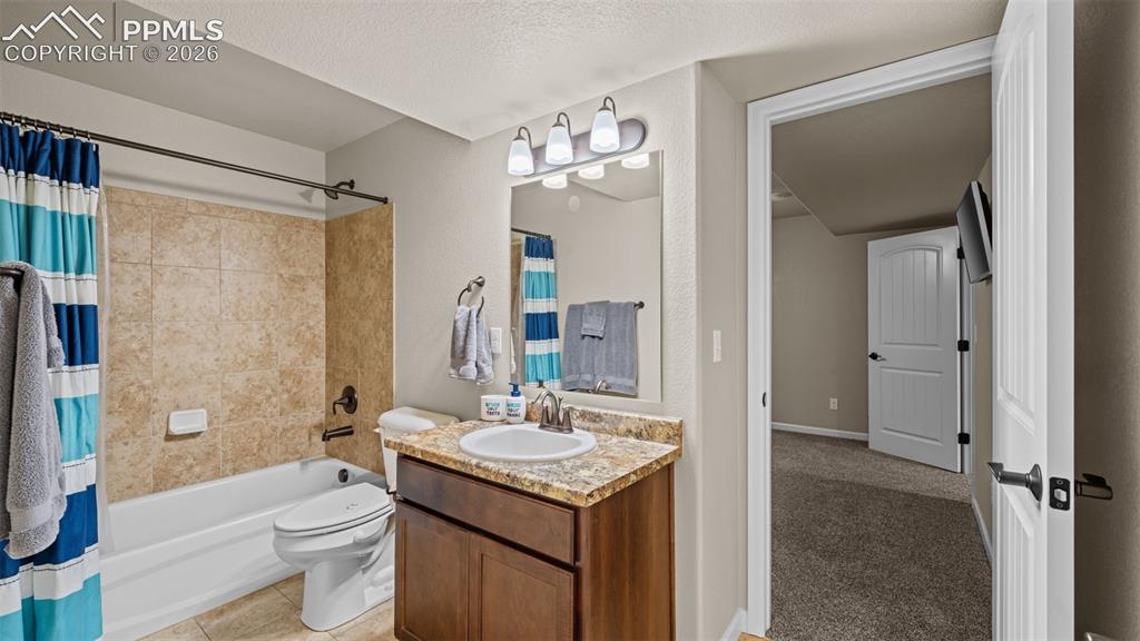 Image 20 of 27: Bathroom featuring a tub/shower combination with tile surround, a single va
