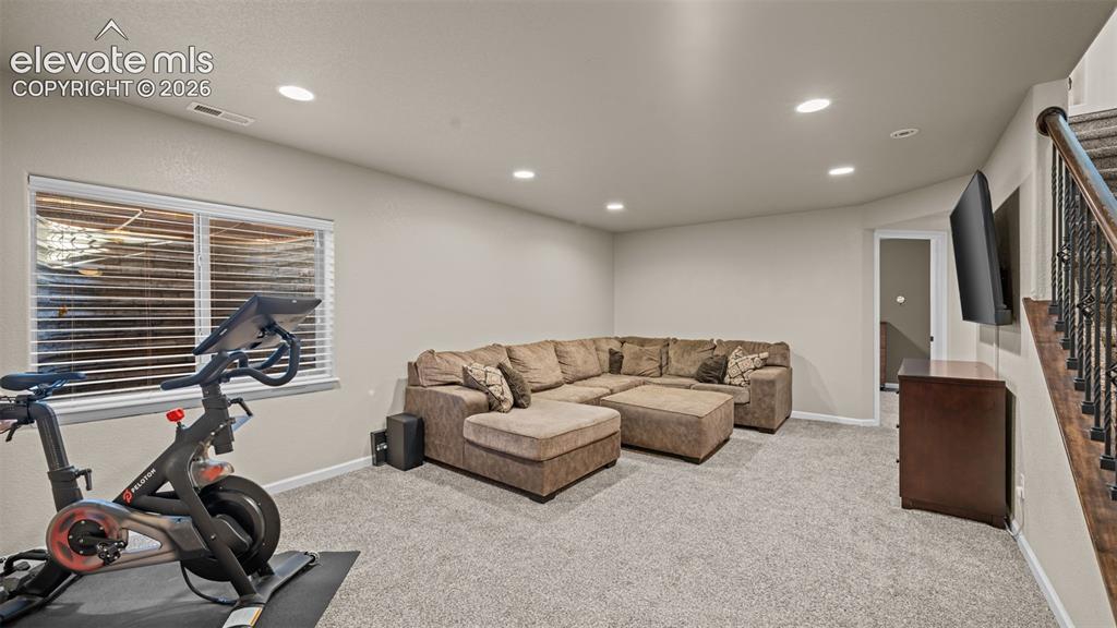Image 22 of 27: Spacious carpeted room featuring recessed lighting, a window with blinds, a