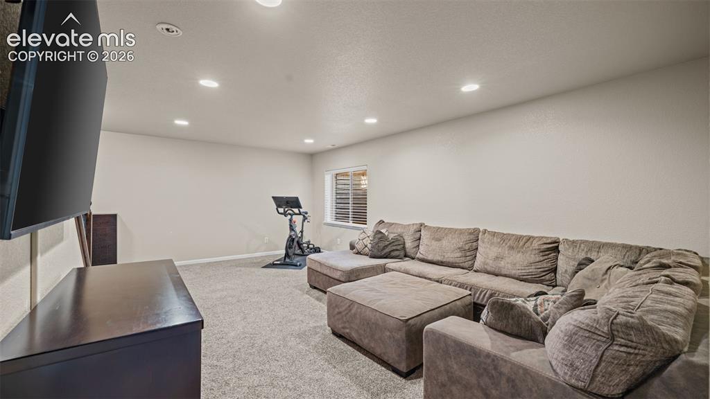 Image 23 of 27: Spacious room featuring neutral wall tones, recessed lighting, and a window