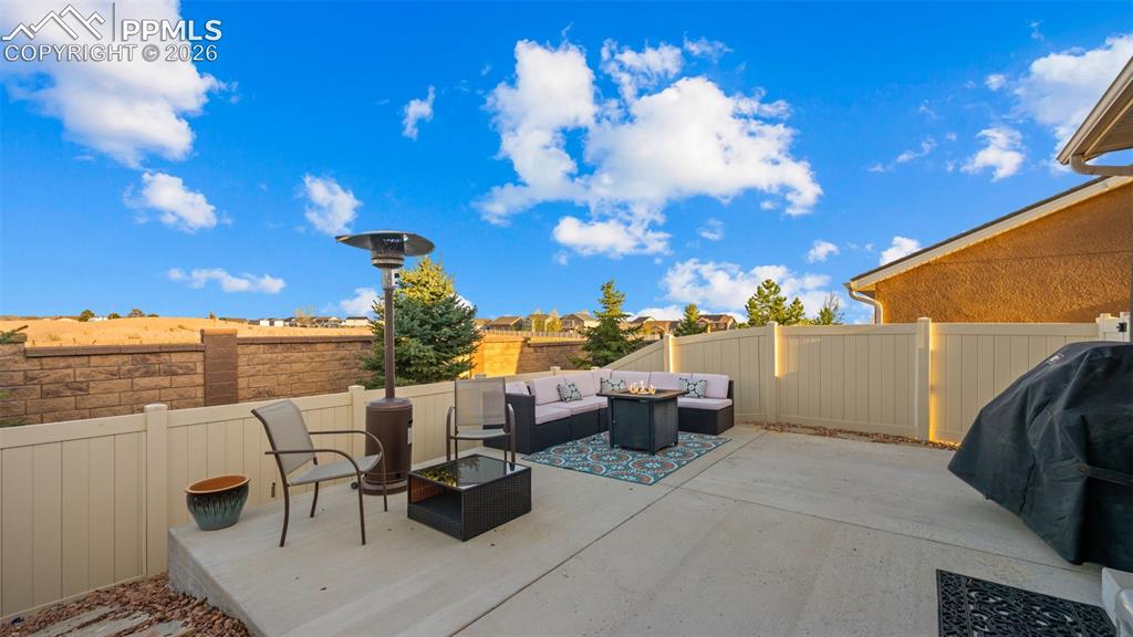 Image 27 of 27: Expansive concrete patio area with a privacy fence