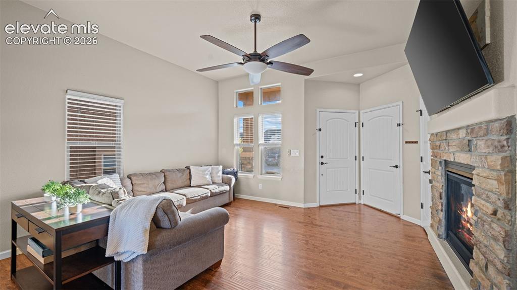 Image 5 of 27: Living area featuring warm wood-finish flooring and a ceiling fan