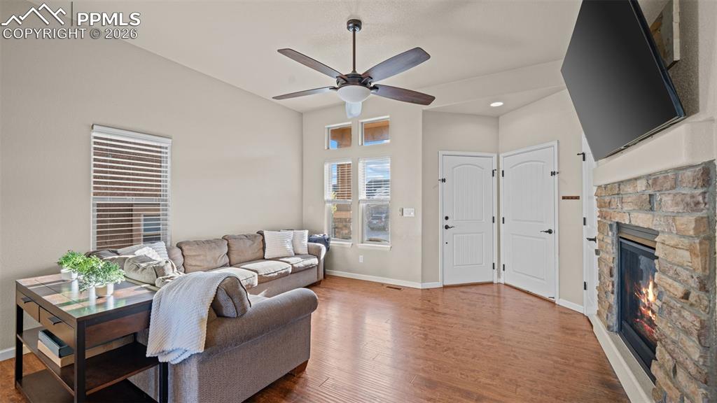 Image 6 of 27: Living area featuring warm wood-finish flooring and a ceiling fan