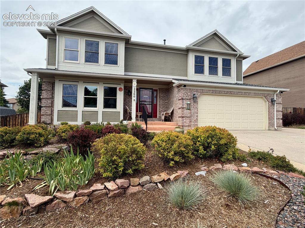Image 1 of 49: Two-story residence featuring a two-car garage, brick facade accents, and a