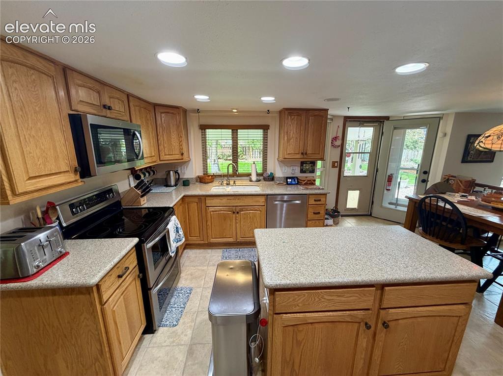 Image 22 of 49: Kitchen featuring wood cabinetry, quartz countertops, and tile flooring