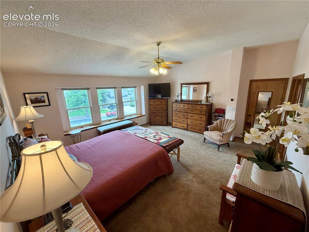 Image 26 of 49: Spacious room featuring multiple windows with natural light, a ceiling fan 