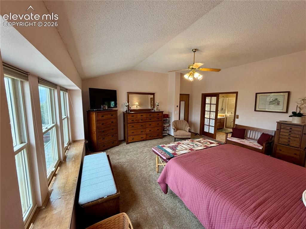 Image 27 of 49: Expansive room with vaulted ceilings and textured finishes, featuring large